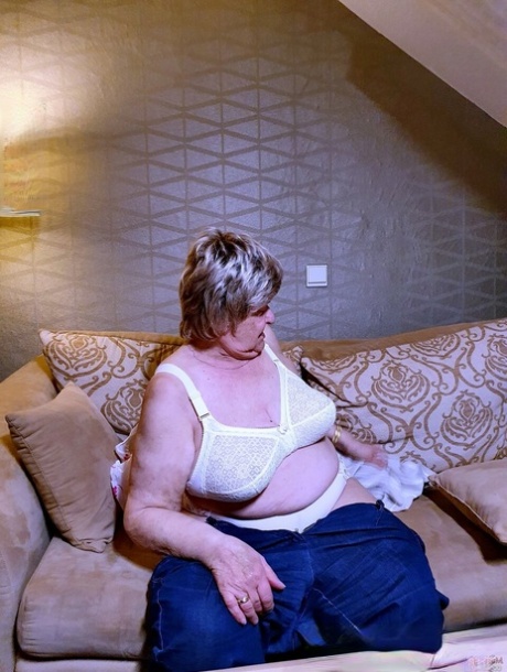 Naughty chubby granny Melba plays with her saggy tits while undressing