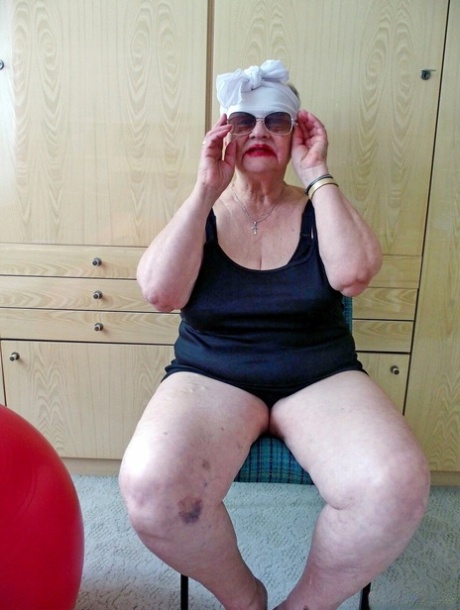Naughty chubby granny Melba plays with her saggy tits while undressing